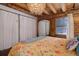 Bright bedroom with a large bed, wood-paneled walls, and large windows at 11498 Pauls Ln, Conifer, CO 80433