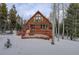 A-frame cabin with large deck and snowy landscape at 11498 Pauls Ln, Conifer, CO 80433