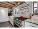 Modern kitchen with stainless steel appliances and rustic wood beams at 11498 Pauls Ln, Conifer, CO 80433