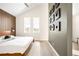 Stylish bedroom with wood accent wall, sleek furniture and ample natural light from two windows at 5780 W 92 Ave, Westminster, CO 80031