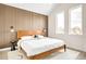 Stylish bedroom featuring a wood accent wall, sleek furniture, and plenty of natural light at 5780 W 92 Ave, Westminster, CO 80031