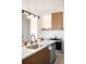 Bright kitchen with a modern faucet, gray cabinets, and stainless steel appliances, under dark pendant lighting at 5780 W 92 Ave, Westminster, CO 80031