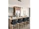 Stylish kitchen island featuring bar seating, granite countertops, stainless steel refrigerator, and sleek cabinetry at 5780 W 92 Ave, Westminster, CO 80031