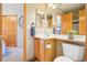 Cozy bathroom featuring a mirrored wall, wood vanity and storage space at 8743 Fairview Oaks Ln, Lone Tree, CO 80124