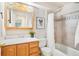 This full bathroom features a wood vanity, framed mirror and tiled shower at 8743 Fairview Oaks Ln, Lone Tree, CO 80124