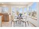 Sunlit breakfast nook with a round table and white chairs by bay windows at 8743 Fairview Oaks Ln, Lone Tree, CO 80124