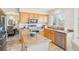 Well-lit kitchen with granite countertops, stainless steel appliances, and natural wood cabinets at 8743 Fairview Oaks Ln, Lone Tree, CO 80124