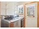 Bright laundry room with modern washer and dryer, shelves, and an exterior door at 8743 Fairview Oaks Ln, Lone Tree, CO 80124