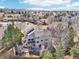 A beautiful gray home with a back deck sits among mature trees in a well-kept neighborhood on a sunny day at 8743 Fairview Oaks Ln, Lone Tree, CO 80124