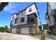 Modern townhome featuring two-car garage, stone accents, and private balcony at 2010 S Holly St # 3, Denver, CO 80222