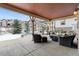 Covered patio with seating area and fireplace, winter scene at 1128 Starglow Pl, Highlands Ranch, CO 80126