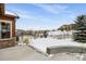 Snowy backyard with view of neighborhood and trees at 1128 Starglow Pl, Highlands Ranch, CO 80126