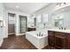 Elegant bathroom with soaking tub, double sinks, and herringbone tile floors at 1128 Starglow Pl, Highlands Ranch, CO 80126