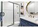 Modern bathroom with blue vanity, frameless shower, and gold accents at 1128 Starglow Pl, Highlands Ranch, CO 80126