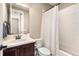 Bathroom featuring a white sink, vanity, toilet, and a combined bathtub and shower with a white shower curtain at 1128 Starglow Pl, Highlands Ranch, CO 80126