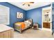 Blue bedroom with twin bed, dresser, and access to bathroom at 1128 Starglow Pl, Highlands Ranch, CO 80126