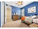 Blue bedroom with twin bed, dresser, and access to another room at 1128 Starglow Pl, Highlands Ranch, CO 80126