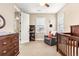 Bedroom with crib, dresser, and adjacent bathroom access at 1128 Starglow Pl, Highlands Ranch, CO 80126