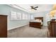 Serene bedroom with carpeted floor, ceiling fan, and large windows at 1128 Starglow Pl, Highlands Ranch, CO 80126