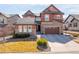 Charming two-story home with stone accents, a well-manicured lawn, and a two-car garage at 1128 Starglow Pl, Highlands Ranch, CO 80126