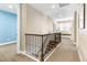 Bright hallway featuring a window seat, a staircase with wrought iron railings, and access to other rooms at 1128 Starglow Pl, Highlands Ranch, CO 80126