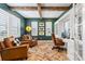 Bright home office with exposed beams, herringbone floors, and leather armchairs at 1128 Starglow Pl, Highlands Ranch, CO 80126