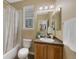 Neutral bathroom with a shower/tub, toilet, and a single sink vanity with a warm wood finish at 4821 Bluegate Dr, Highlands Ranch, CO 80130