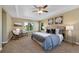 Spacious bedroom featuring a tray ceiling, two chairs, a king-sized bed, and large windows at 4821 Bluegate Dr, Highlands Ranch, CO 80130