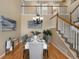 Bright dining room with hardwood floors, staircase, chandelier, and formal place settings at 4821 Bluegate Dr, Highlands Ranch, CO 80130