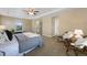 Neutral main bedroom featuring a tray ceiling, two chairs, a king-sized bed, and large windows at 4821 Bluegate Dr, Highlands Ranch, CO 80130