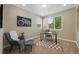 Well-lit office with neutral colors, a large window, a desk and a comfortable chair with a footstool at 4821 Bluegate Dr, Highlands Ranch, CO 80130