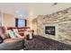 Finished basement includes stone fireplace, plush carpet, and comfortable seating for relaxing at 11803 E 114Th Pl, Commerce City, CO 80640