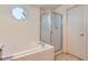 Clean bathroom features a shower, tub, an octagon window and a door to the exterior at 11803 E 114Th Pl, Commerce City, CO 80640