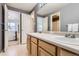 Bathroom with double sinks, white countertop, wood cabinets, and neutral walls at 11803 E 114Th Pl, Commerce City, CO 80640