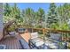 Outdoor deck features ample seating, a glass table and a swing with views of mature pine trees at 11803 E 114Th Pl, Commerce City, CO 80640