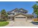 Beautiful two-story home with a three-car garage, manicured lawn and mature landscaping at 11803 E 114Th Pl, Commerce City, CO 80640