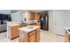 Modern kitchen with stainless steel appliances, wood cabinetry, and an island counter at 11803 E 114Th Pl, Commerce City, CO 80640