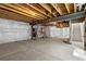 Unfinished basement with exposed wooden beams, concrete floors, and white walls at 223 Washington St, Erie, CO 80516