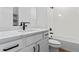 A modern bathroom with white cabinets, black hardware, and white tiled shower at 223 Washington St, Erie, CO 80516