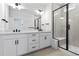 Modern bathroom featuring a dual sink vanity, black hardware, large mirror, and a glass enclosed shower at 223 Washington St, Erie, CO 80516