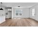 Contemporary living area featuring hardwood floors, a modern light fixture, and an adjacent kitchen at 223 Washington St, Erie, CO 80516