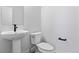 Modern powder room featuring a pedestal sink, black fixtures, and a toilet at 223 Washington St, Erie, CO 80516