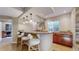 Basement bar area with granite countertop, three barstools, and cabinetry beneath a window at 7734 Terry Ct, Arvada, CO 80007