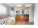 Bright bathroom featuring a soaking tub, double vanity, and granite countertops at 7734 Terry Ct, Arvada, CO 80007