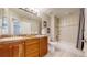 Bright bathroom featuring a double sink vanity with granite countertop and tiled shower with bathtub at 7734 Terry Ct, Arvada, CO 80007