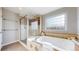 Bathroom featuring a soaking tub and glass enclosed shower with custom tile work at 7734 Terry Ct, Arvada, CO 80007