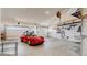 Spacious garage featuring a red Porsche, two garage doors and organized wall mounted shelving at 7734 Terry Ct, Arvada, CO 80007