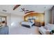 Sun-filled main bedroom with ceiling beams, wood accent wall, and decorative lighting at 7734 Terry Ct, Arvada, CO 80007