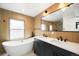 Modern bathroom featuring double sinks, a soaking tub, sleek fixtures, and stylish tile work at 4131 Osage St, Denver, CO 80211