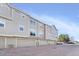 Multi-story townhome with attached garages and neutral siding offering convenient parking at 209 W Jamison Cir # 32, Littleton, CO 80120